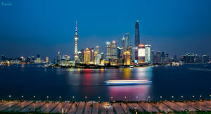 上海夜景天際線，發光的建築物和河上的小船。