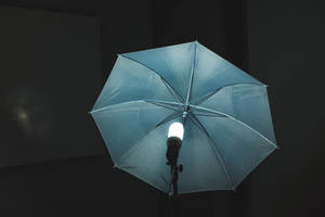 藍色攝影棚雨傘在黑暗房間中擴散明亮光線。