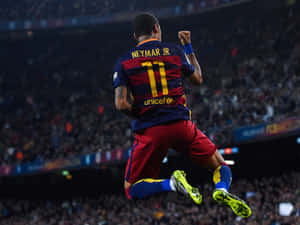 足球運動員尼馬（Neymar Jr.）在夜間於體育館跳起慶祝入球。