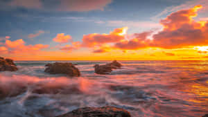 夕陽下的海洋，海浪拍打岩石