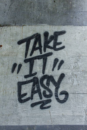 裂縫混凝土牆上的塗鴉訊息 take it easy