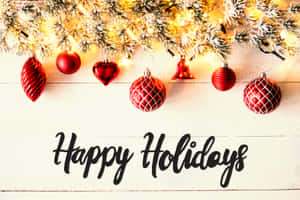 白色木頭上的「Happy Holidays」文字與紅色裝飾品和雪松枝。