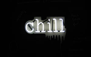 一個白色結他形霓虹燈牌，在黑暗的牆上顯示 chill，並有筆記。