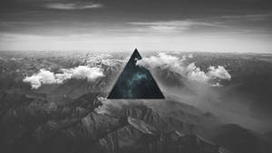 黑白山景，發光的宇宙三角形漂浮在山峰之上。