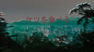 青綠色調的黃昏城市天際線，以樹木為框，疊加日文字句。
