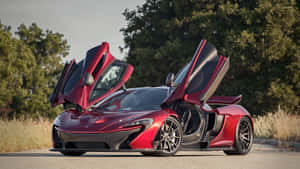 紅色McLaren跑車，鷗翼車門打開，停在日落時分樹木附近的道路上。