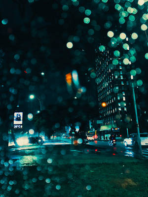 車窗上的雨滴模糊了夜晚的城市燈光。