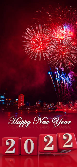 城市天際線上的紅色和藍色煙火，反光表面上有 'Happy New Year 2022' 方塊。
