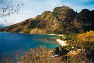 熱帶海灘，背景是碧綠的海水和綠色的山脈。 — 島嶼 壁紙
