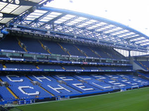 空的藍色體育場座位在綠色球場上以白色字母拼出CHELSEA。