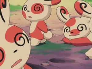 四隻帶有紅色漩渦圖案的捲捲耳寶可夢站在草地上。
