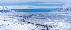 雪山山谷，蜿蜒道路與遠方海洋