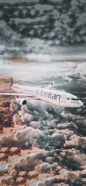 斯里蘭卡航空飛機在戲劇性的天空下飛越色彩斑斕的雲層。 — Galaxy M 壁紙