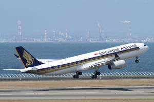 新加坡航空飛機在日落時分於工業海岸附近降落