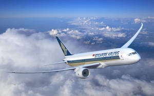 新加坡航空飛機在晴朗藍天的雲層上方高高飛行