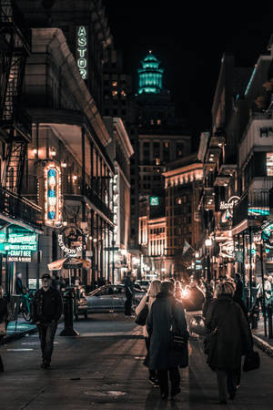 夜晚城市街道，閃爍霓虹燈招牌和行人行走。
