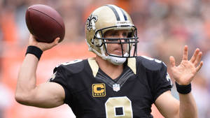 NFL四分衛德魯·布里斯身穿聖徒隊球衣，在比賽中準備投擲橄欖球。