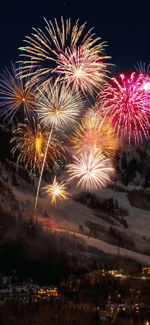 五彩繽紛的煙火照亮了夜晚白雪覆蓋的山村。 — 煙火 壁紙