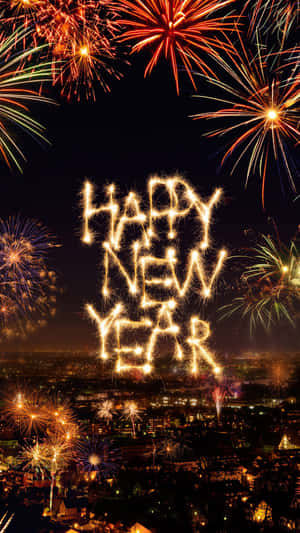 煙花在夜晚的城市上空拼出「Happy New Year」。 — 煙火 壁紙