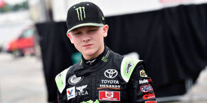 年輕賽車手穿著 Toyota Menards 賽車裝備向前看。