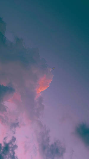 暮色中彩色雲層後的新月