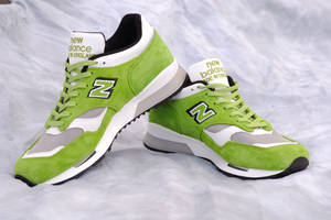 青檸綠色 New Balance 運動鞋，帶有白色和黑色點綴，銀色布料背景。 — 卡通鞋 壁紙
