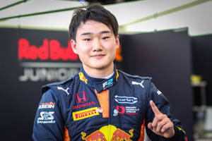 身穿 Red Bull Junior 裝備的年輕日本賽車手指向鏡頭。