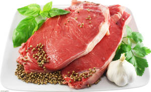 白色碟上的生牛肉扒配香草和香料。