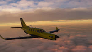 黃色飛機在夕陽多彩雲層上飛行。