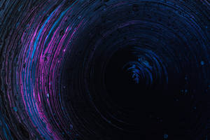 抽象宇宙漩渦，黑色背景上旋轉的藍色和洋紅色顏料