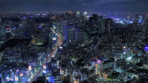 夜間城市景觀，明亮的建築物和移動的車燈。