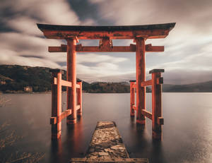 湖中的紅色木製鳥居，配有石徑和山景背景。 — 日本龍動畫 壁紙