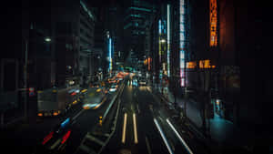 夜晚城市街道，有車燈光軌同發光嘅霓虹招牌。