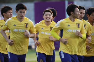 日本足球運動員在訓練中身穿黃色球衣慢跑。 — 日本 壁紙
