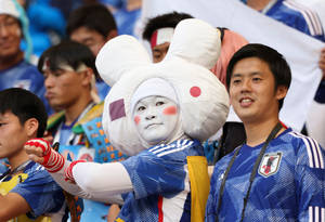 一位身穿兔子吉祥物服裝的日本足球迷在體育場歡呼。 — 日本 壁紙