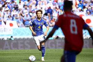 日本足球員4號在日間比賽中運球。 — 日本 壁紙