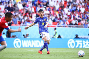 日本足球運動員六號在日間比賽中運球。 — 日本 壁紙
