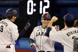 日本棒球運動員在比賽獲勝後擊掌。