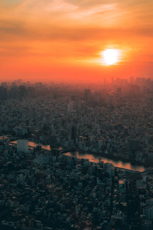 夕陽下的密集城市，河流蜿蜒穿過建築物。
