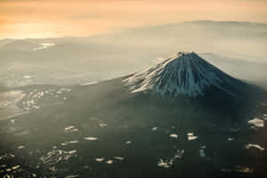 日出時分白雪皚皚的富士山，伴隨著霧氣山谷和金色光芒。 — 日出 壁紙