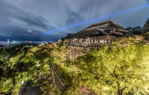 夜間照亮的小山上俯瞰城市的日本寺廟