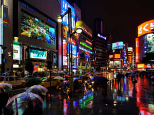 繁忙的雨夜東京街道，閃爍的霓虹招牌和撐傘的人們。