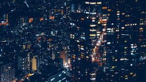 從上方俯瞰，發光的窗戶和明亮的街道的夜間城市景觀。
