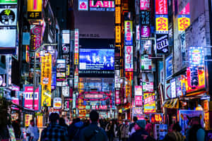 人群在發光的霓虹燈下行走於繁忙的東京夜街。