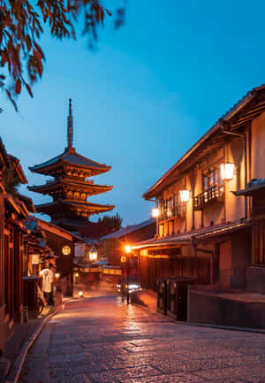 黃昏時分的傳統日本街道，燈籠閃耀，背景有寶塔。 — 日本 壁紙