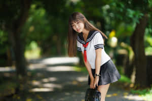 一個穿著校服的女孩在公園裡拿著袋子微笑著靠著。