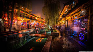 傳統中國小鎮的夜間運河步道，有發光的燈籠和濕漉漉的石板路。