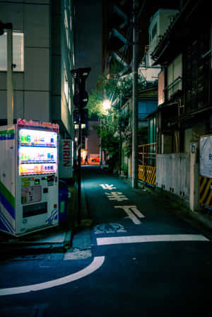 一部明亮照明的自動販賣機在夜晚東京一條黑暗潮濕的小巷中。