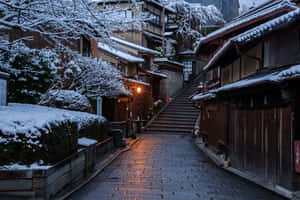 雪覆蓋的日本街道，夜晚有發光的燈籠和石階。