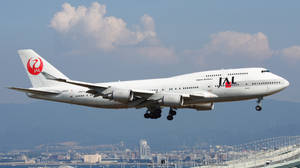 日本航空波音747降落，城市在背景中